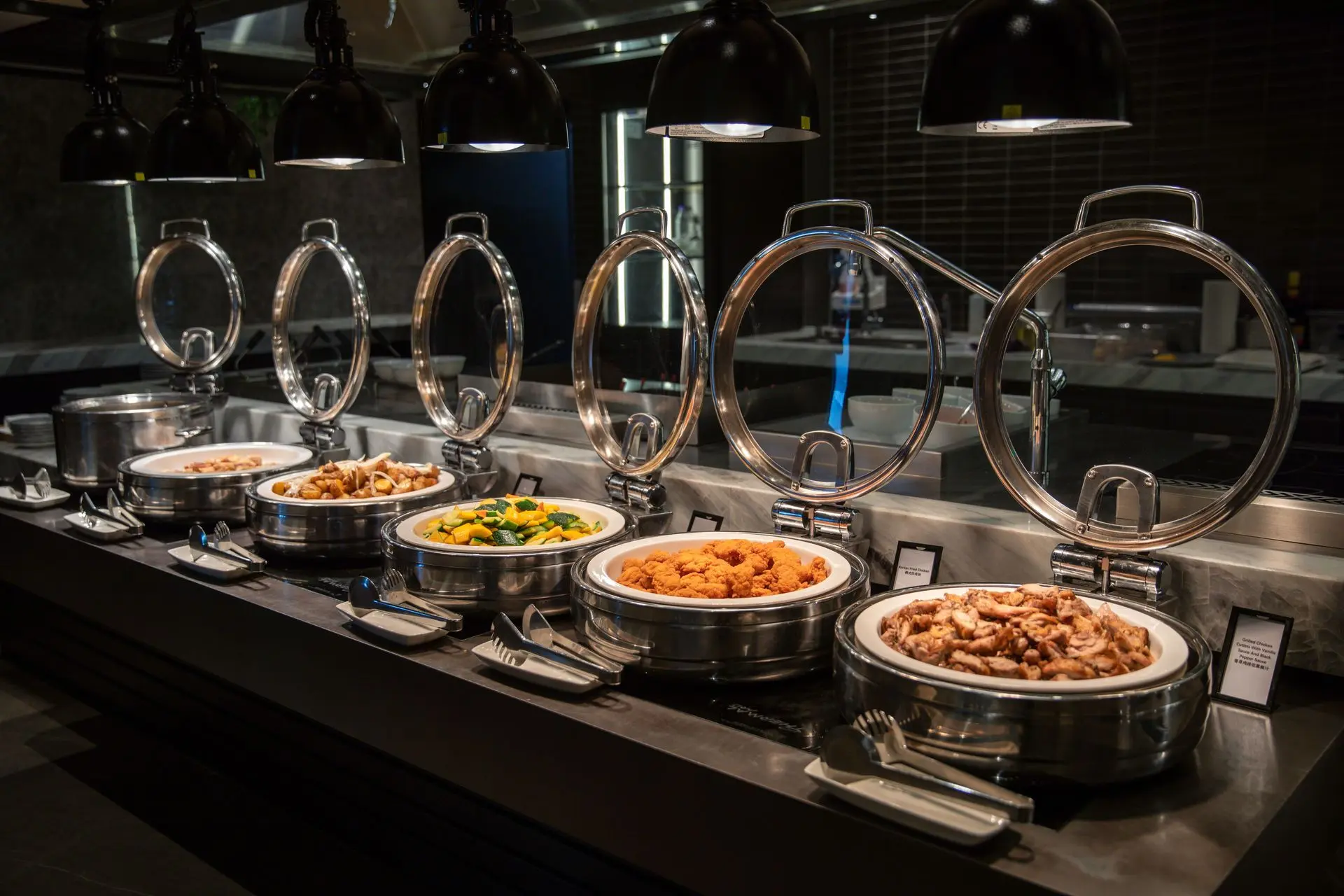 Hotel buffet setup with stainless steel serving equipment and food stations